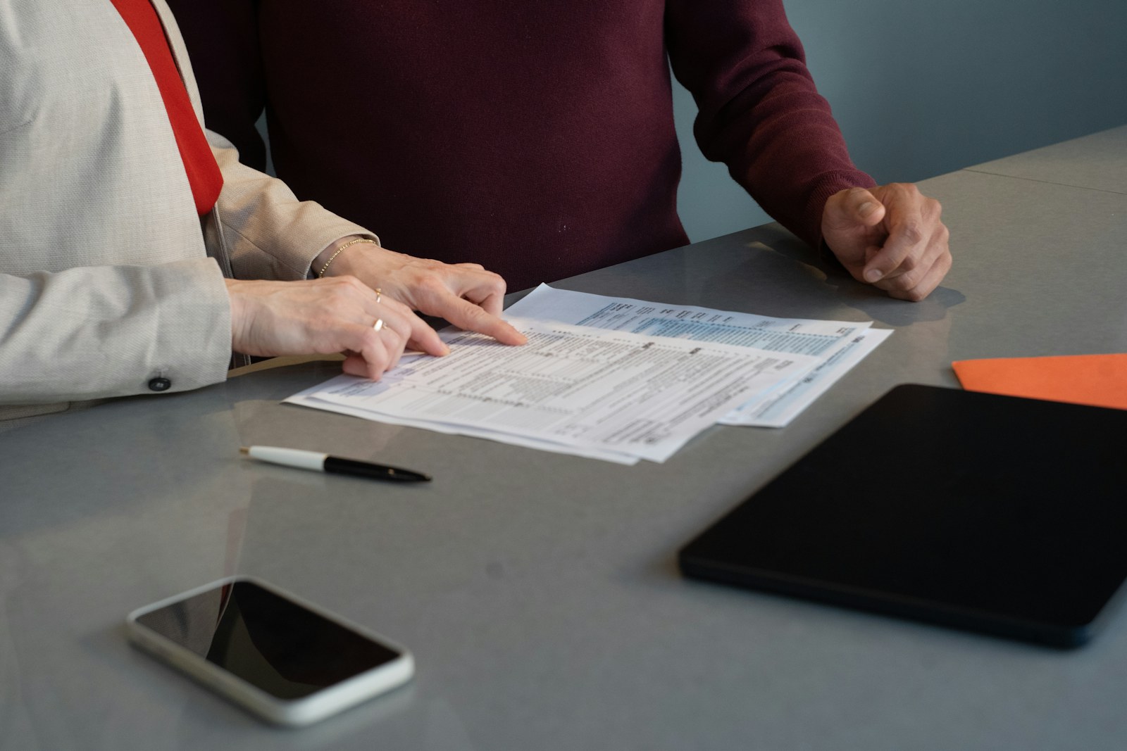 Two advisers reviewing finance documents at a meeting table