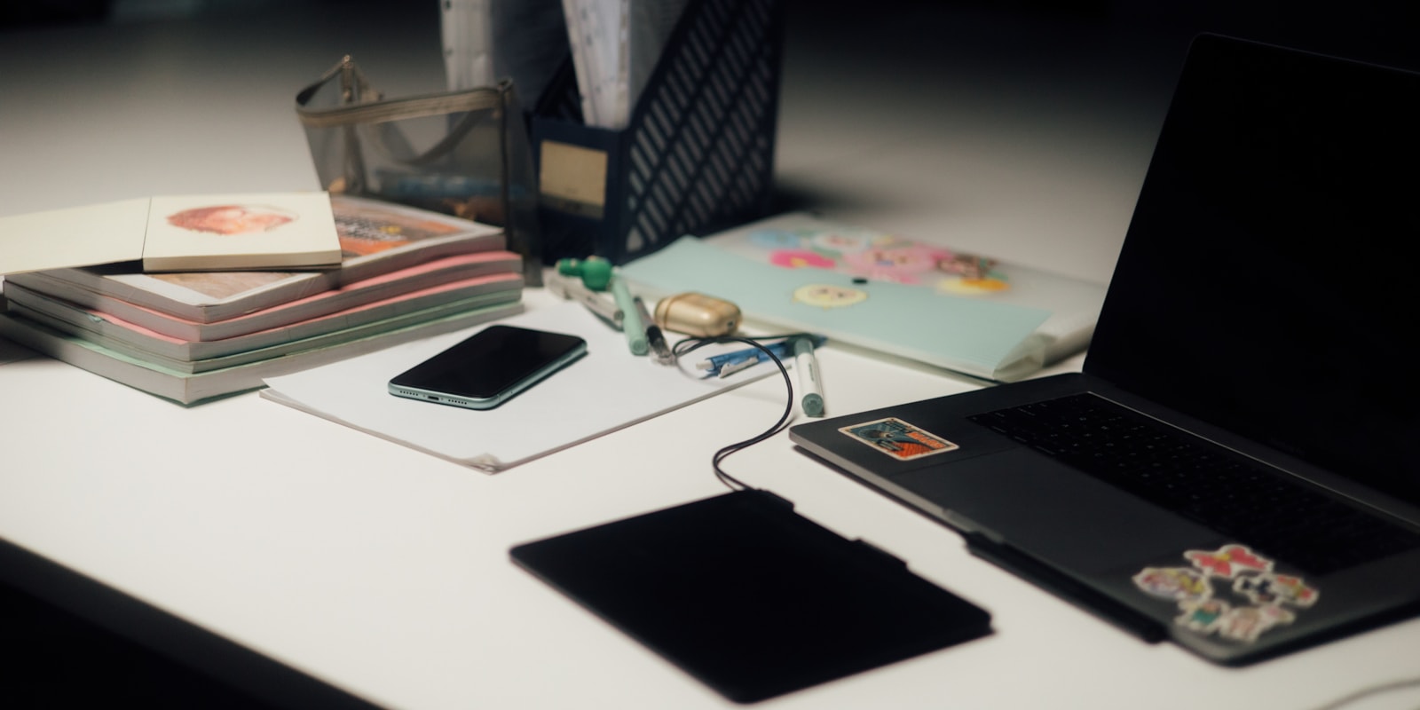 Cluttered office desk with laptop, phone and unfinished paperwork